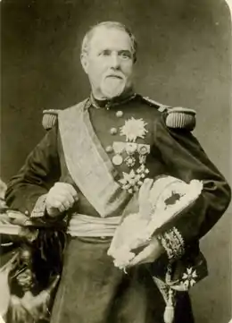 Photo en noir et blanc d'un homme, debout, en tenue de général et portant des décorations.