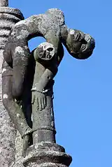 Le calvaire près de l'église paroissiale Saint-Hernin, croix en tau avec le mauvais larron.