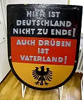 Panneau ouest-allemand noir, rouge et or indiquant « Hier ist Deutschland nicht zu Ende. Auch drüben ist Vaterland!"