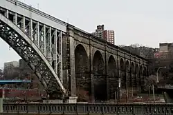 La transition de l'arc en acier au-dessus de la rivière Harlem aux arches en pierre au-dessus de l'autoroute Major Deegan