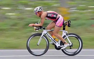 Une cycliste en position aérodynamique sur son vélo.