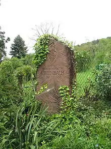 Photo couleur d’un menhir de grès rose gravé.