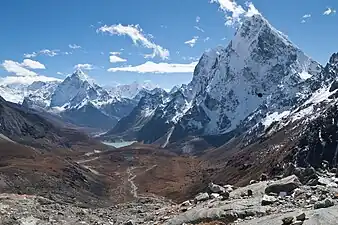 Dans le Khumbu, le sommet du Cholatse vu depuis la passe de Cho, plus loin dans la perspective du petit lac le sommet d'Ama Dablam. Quelques nuages cirrus dans le ciel bleu. Octobre 2009.