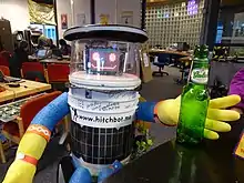 Photo d'un robot humanoïde tendant une main vers une bouteille de bière vide.