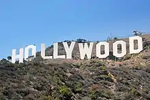 Photographie en contreplongée sur le panneau Hollywood, sous un ciel ensoleillé.