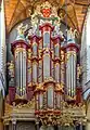 Grande orgue, dont les tuyaux sont soulignés par des encadrements or et rouge.