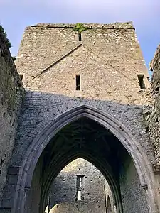 Photographie montrant une tour construite sur la croisée du transept d'une église partiellement ruinée.