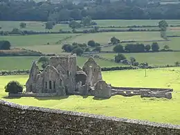Photographie d'une abbaye partiellement ruinée vue depuis un édifice haut placé.