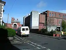 Un véhicule est stationné dans une rue à côté d'un bâtiment.