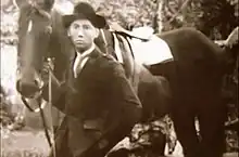 Photo sépia d'un homme asiatique avec un cheval.