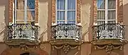 Ferronneries de l'hôtel Davasse avec représentation des trois fleurs des Jeux Floraux : la violette, l'églantine et le souci.