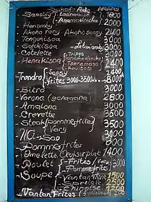 une liste de plats et de prix sur un tableau noir