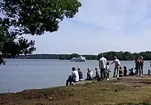 Photo de gens assis au bord d'un cours d'eau