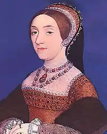 Portrait de trois-quart d'une femme portant une coiffe, une robe orange et plusieurs colliers