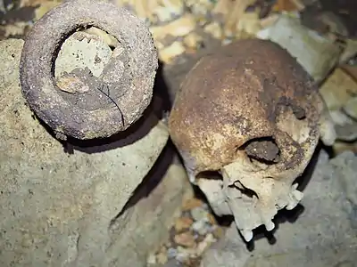 Crâne humain et bracelet-monnaie trouvés au fond de la grotte d'Iroungou