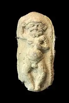 Sculpture en ronde-bosse d'un dieu grimaçant levant le bras droit.