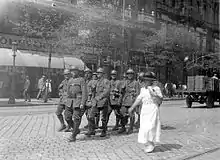 Photo noir et blanc de soldats en patrouille dans une rue.