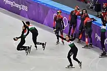 Les patineurs hongrois ravis - derrière eux, les patineurs canadiens souriants.