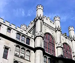 Photo en contre plongée d'un bâtiment en pierre style gothique avec de larges vitres