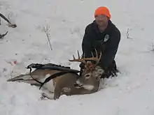 Un chasseur avec un cerf de Virginie.