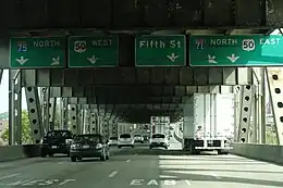 Photographie d'une autoroute à quatre voies située  sur le niveau inférieur d'un pont.