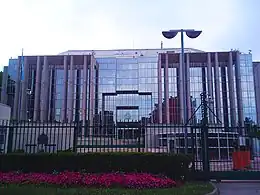 Photographie de la façade de verre d'un bâtiment, en légère contre-plongée.