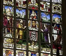 vitrail représentant à droite la reine Élisabeth priant revêtue d'un long manteau violet brodé d'hermine