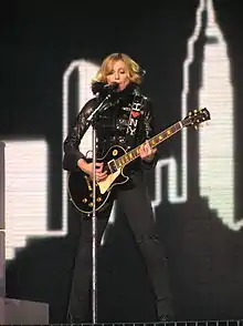 Photographie de Madonna avec une guitare électrique pendant le Confession Tour.