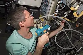 Réparation du générateur d'oxygène de la station spatiale durant l'expédition 11.