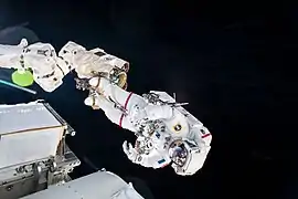 Thomas Pesquet attaché au bras robotique de l'ISS lors de l'installation des nouveaux panneaux solaires de la station spatiale.