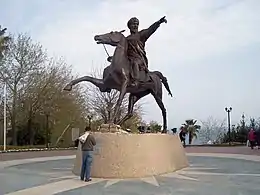 Photographie d'une statue en extérieur d'un homme à cheval brandissant une épée