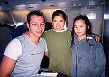 Ian Thorpe, assis dans un avion, posant pour une photo avec deux enfants.