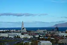 Image d'une ville islandaise avec une grande église grise au bord de la mer