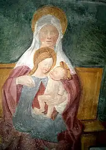 Peinture murale représentant une femme sur les genoux d'une autre et tenant un bébé dans les bras.