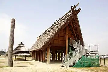 Maison longue surélevée. Vue sur le pignon, petit abri. Ikegami-sone, Izumi, préfecture d'Osaka