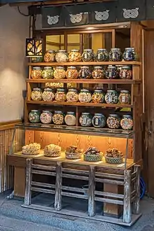 Étagère en bois éclairée avec de nombreux pots en verre contenant des cookies à vendre, près de la rue Kaminarimon-dori, Asakusa.