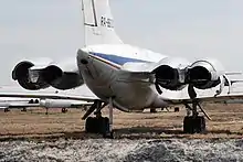 il-62 vue de l'arrière. Tout à l'arrière de l'avion, une tige téléscopique, terminée par deux petites roues, appuie sur le sol.