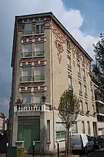 Immeuble en briques rouges au croisement avec la rue Curie.
