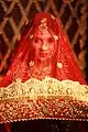 Mariée indienne portant un voile rouge brodé d'or (2022).