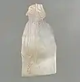 Élément en nacre gravé représentant une femme portant une flûte et un pendentif en forme de sceau-cylindre.