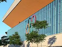 Photo d'une façade d'un bâtiment sur laquelle sont fixés des anneaux olympiques.