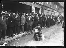 File d'attente d'hommes le long d'un trottoir.