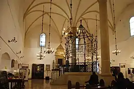 Intérieur de la synagogue Stara à Kazimierz avec la bimah entre les piliers et l'arche sainte au fond.