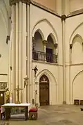 Intérieur de la Bonifatiuskerk montrant la porte à gauche de l'autel menant vers l'entresol et son balcon visibles au-dessus de la porte.