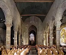 Photographie d'un intérieur d'église avec une nef séparée du transept par un arc triomphal imposant