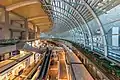 Vue large sur l'intérieur de la galerie commerciale The Shoppes au Marina Bay Sands. Couloirs éclairés, escalator et toit voûté en verre transparent. Juin 2018.