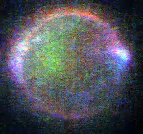 Image de Io présentant de nombreux points verts, bleus, violets et rouge et deux aurores blanches de part et d'autre de la lune.
