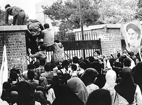 Des étudiants iraniens escaladant la clôture de l'ambassade américaine à Téhéran, le 4 novembre 1979.