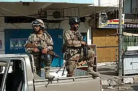 Deux soldats de l'armée irakienne montent la garde à Adhamiya (en), près d'un site de vote pour le référendum historique d'octobre 2005.
