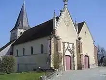 Vue d'ensemble de l'église paroissiale. Ici : la nef, le portail, le clocher-tour et le parvis de l'édifice religieux illois.